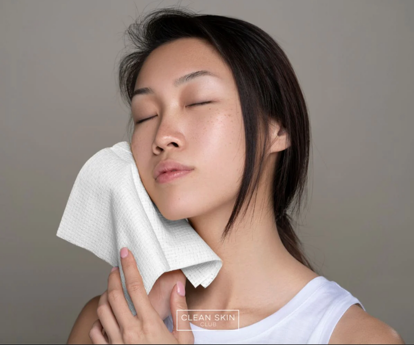 a woman wiping her face with a towel